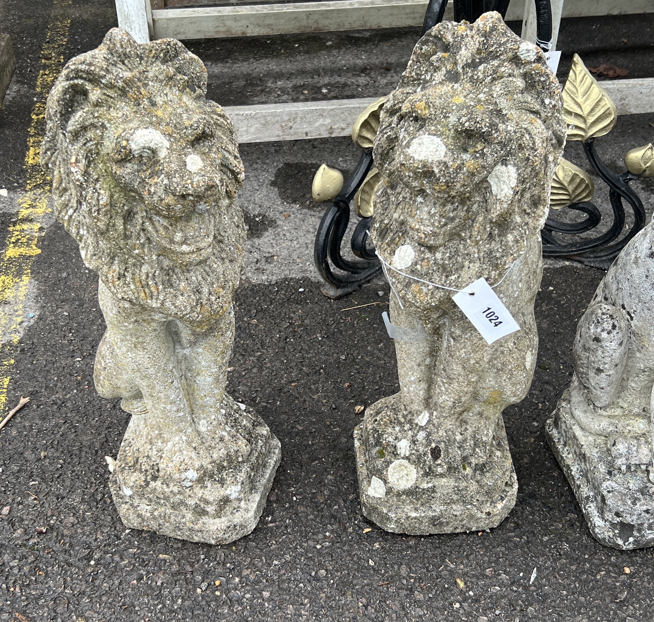 A pair of reconstituted stone seated lion garden ornaments, height 55cm